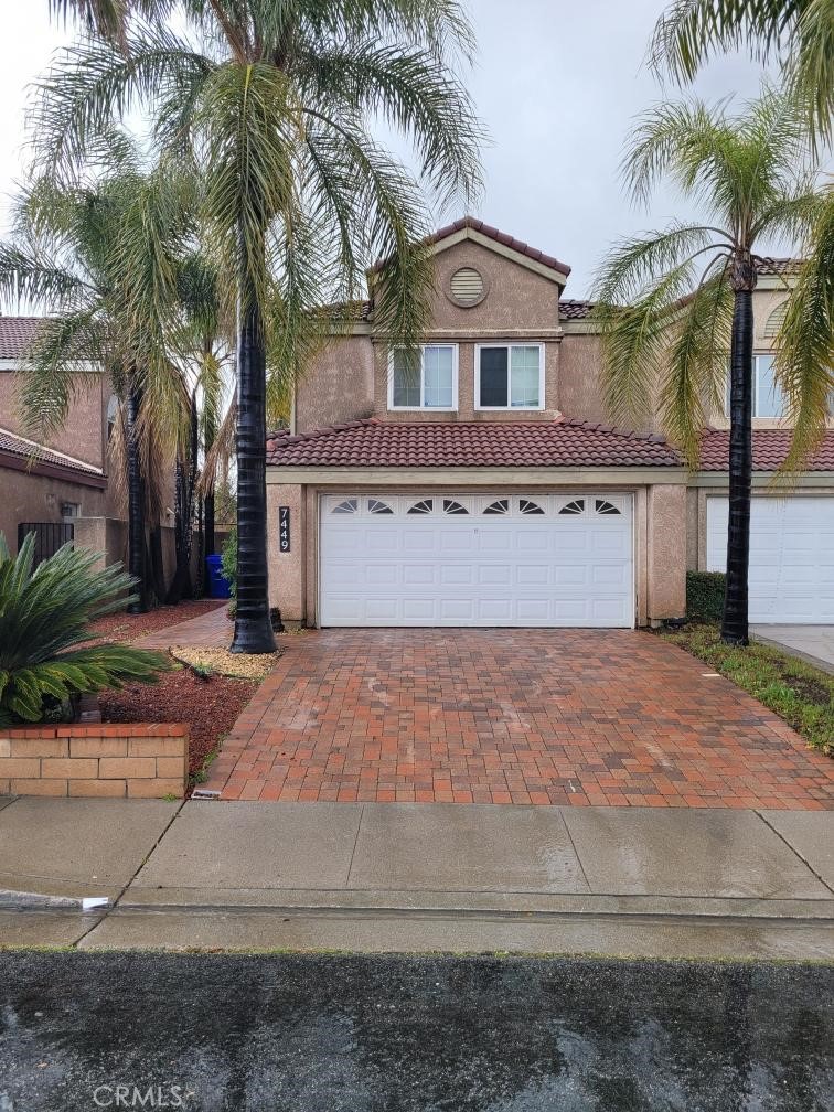 a front view of a house with a yard and palm trees