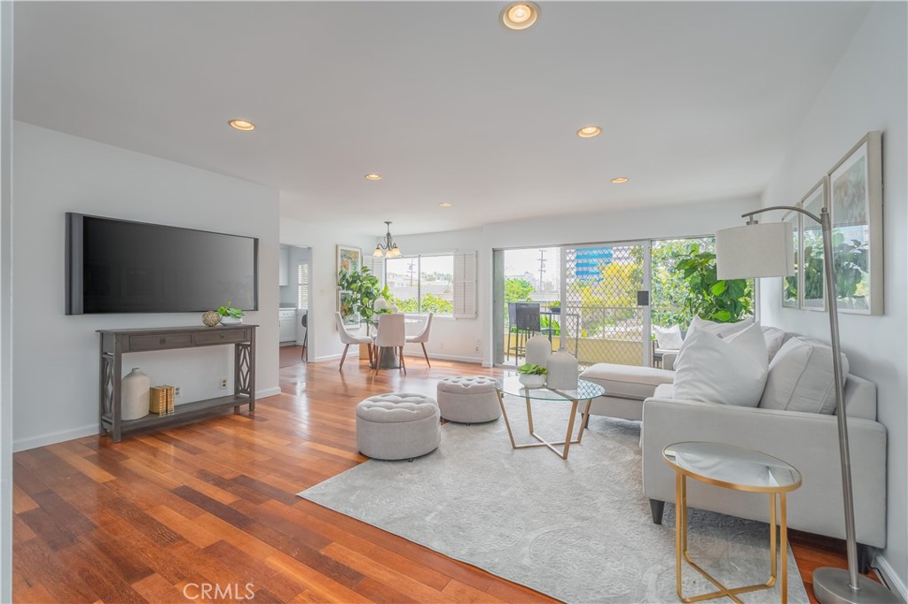 a living room with furniture a flat screen tv and a large window