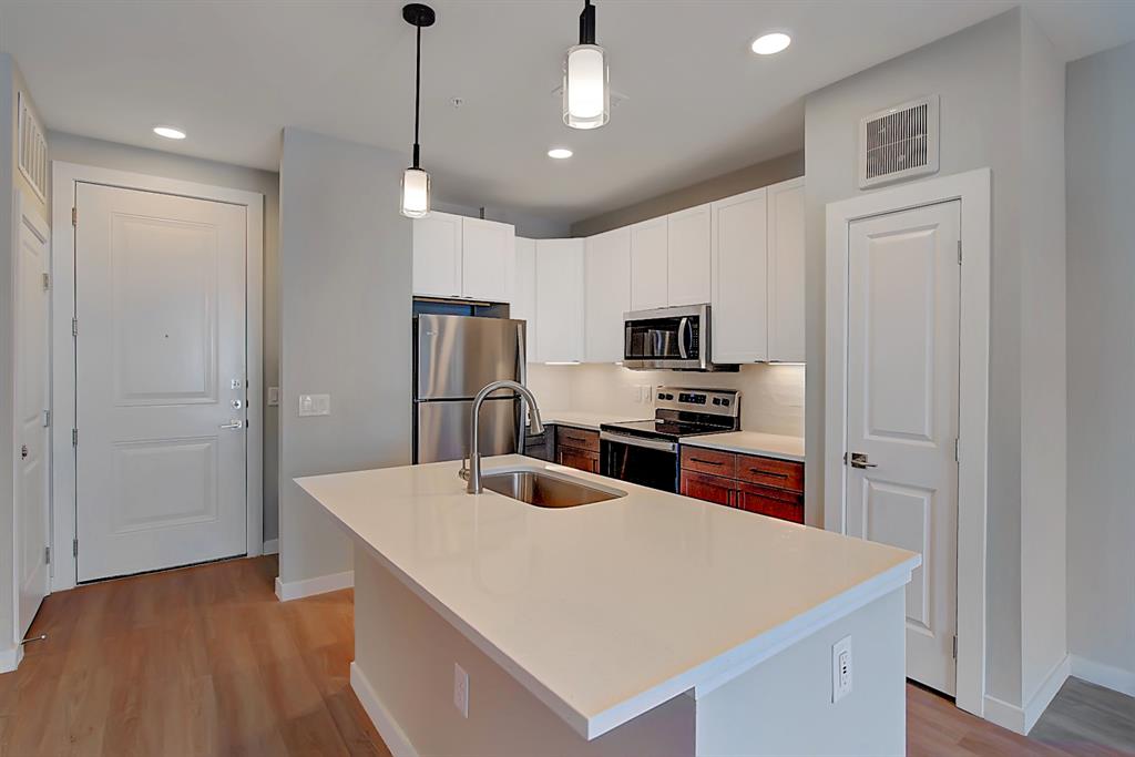 a kitchen with kitchen island a counter top space stainless steel appliances and cabinets