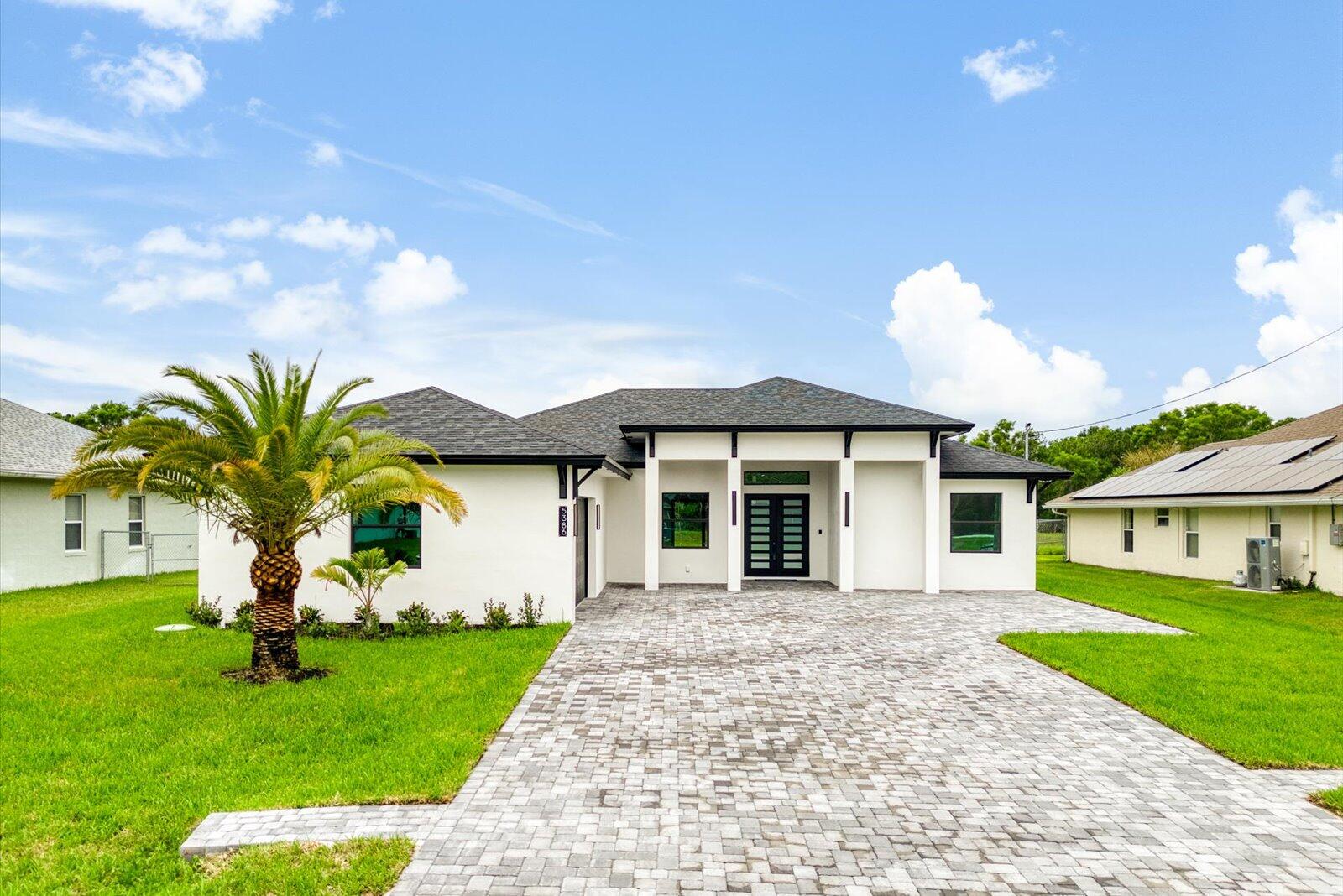 a front view of a house with a garden and plants