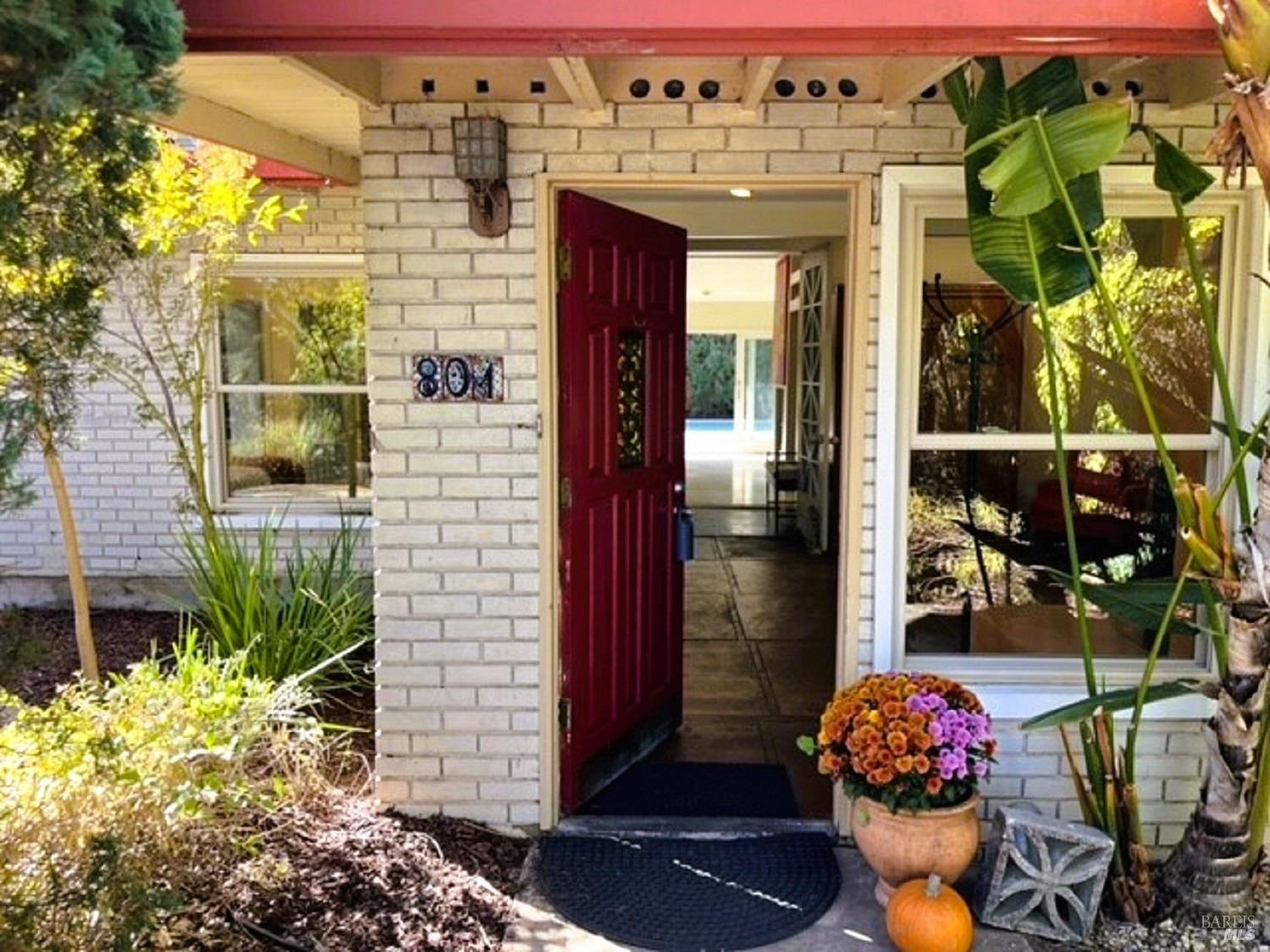 a front view of a building with outdoor seating and flowers