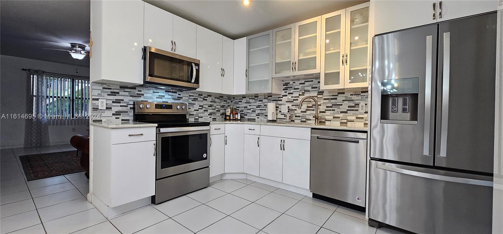 a kitchen with stainless steel appliances a refrigerator sink and microwave