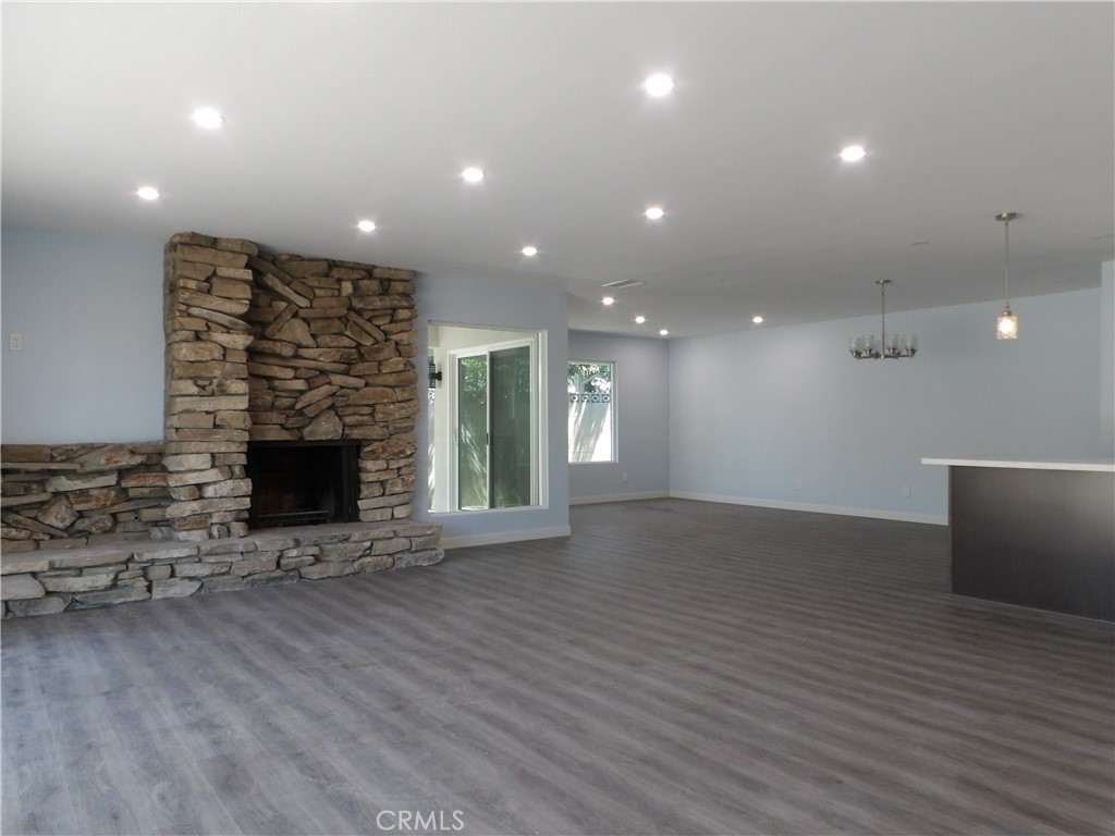 a view of an empty room with a fireplace and a window