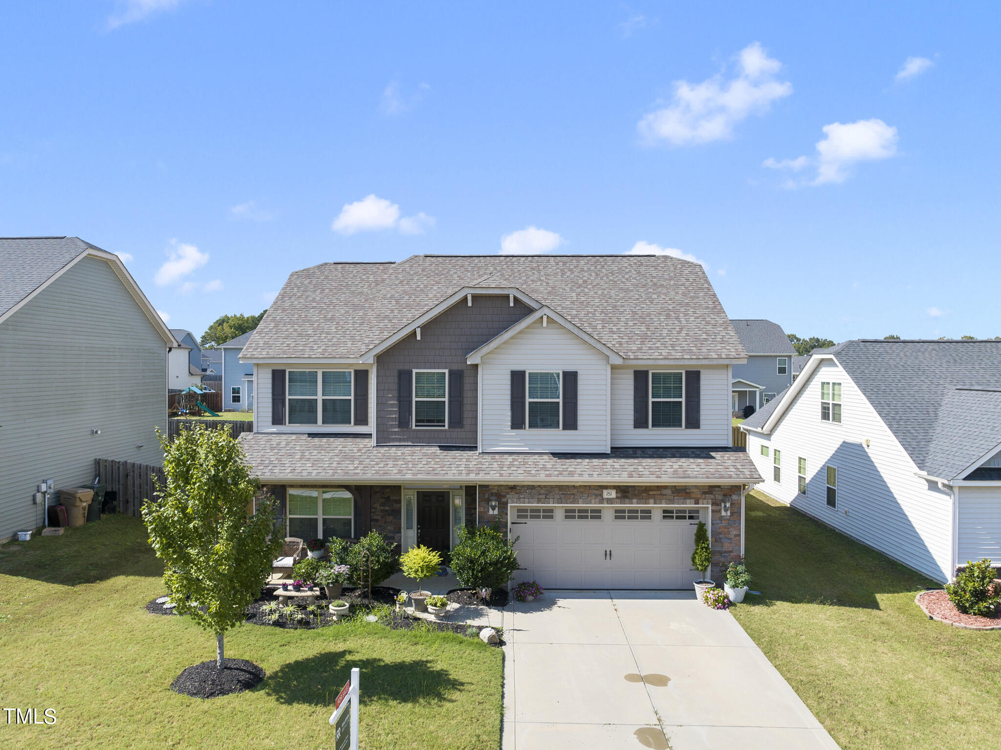 a front view of a house with a yard garden and outdoor seating