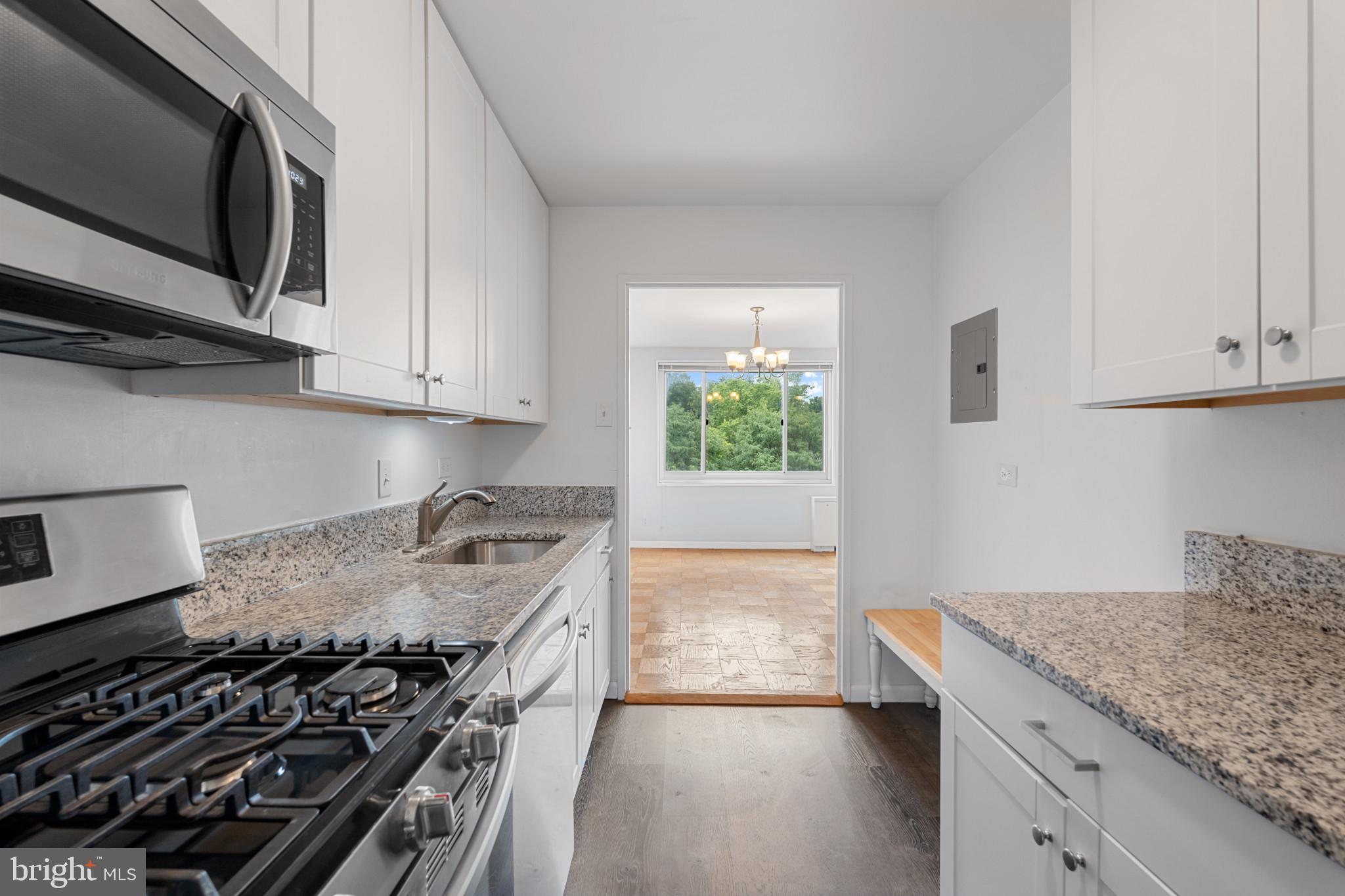 a kitchen with a stove and a white wooden cabinets