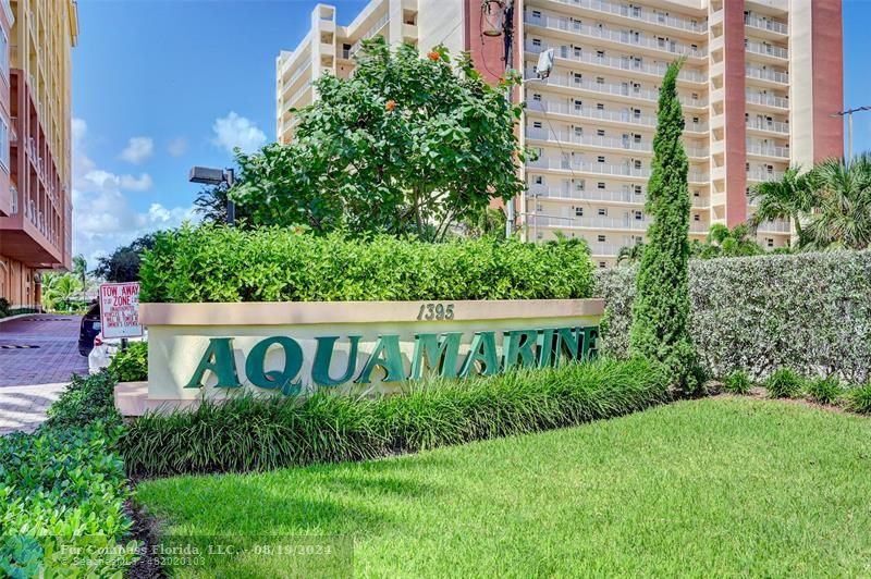 a view of sign board with tall buildings