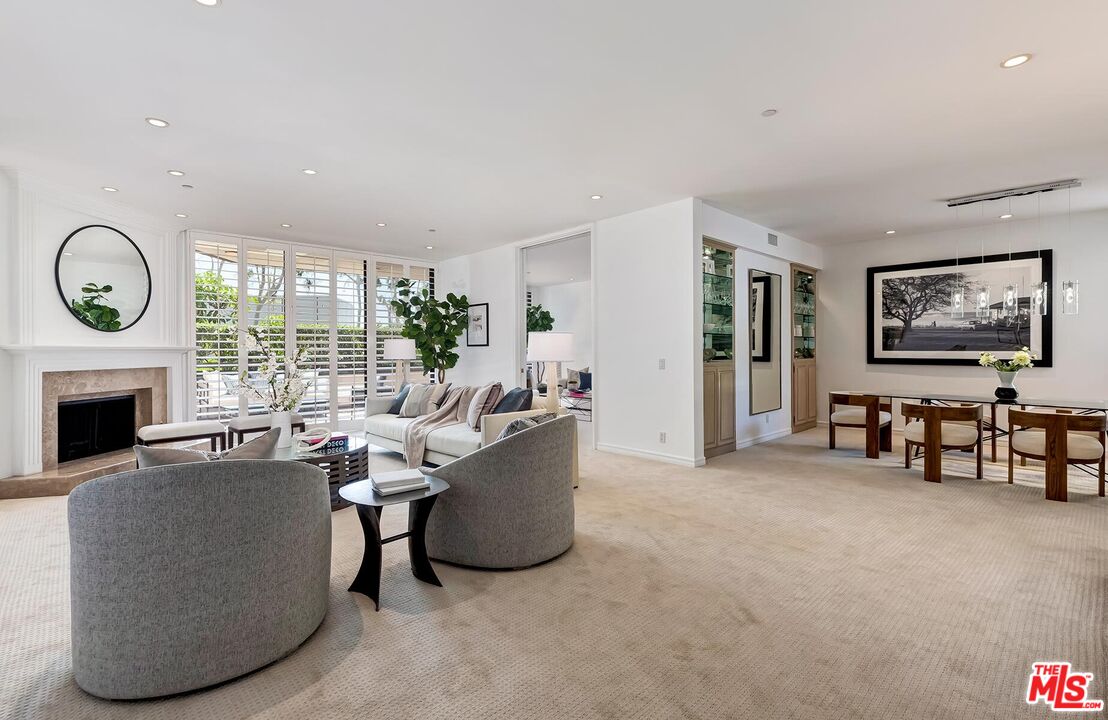 a living room with furniture a fireplace and a large window