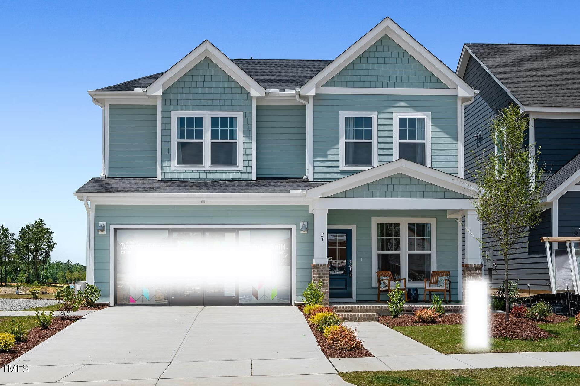 a front view of a house with yard and parking