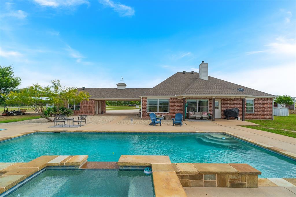 a front view of a house with swimming pool having outdoor seating