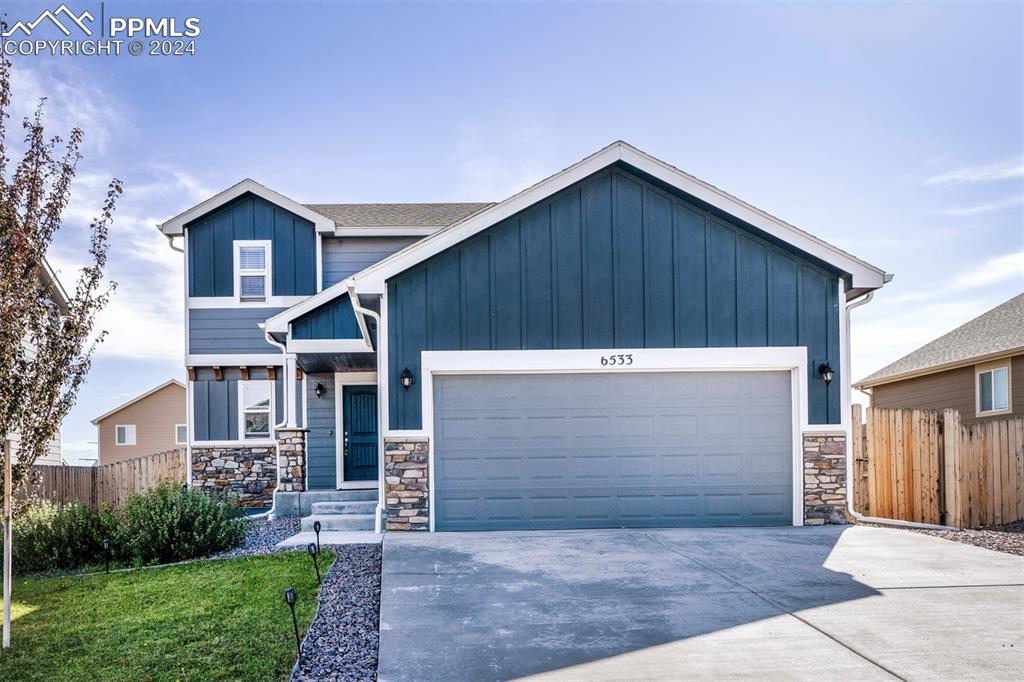 View of front of property featuring a garage and a front yard