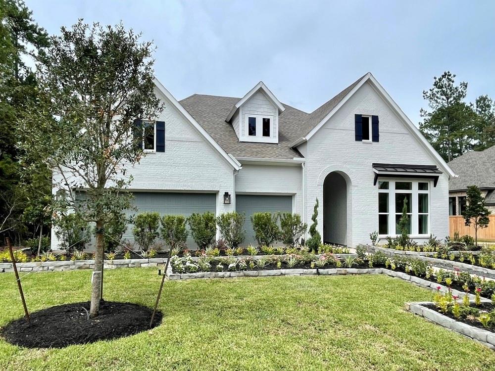 a front view of a house with garden and trees