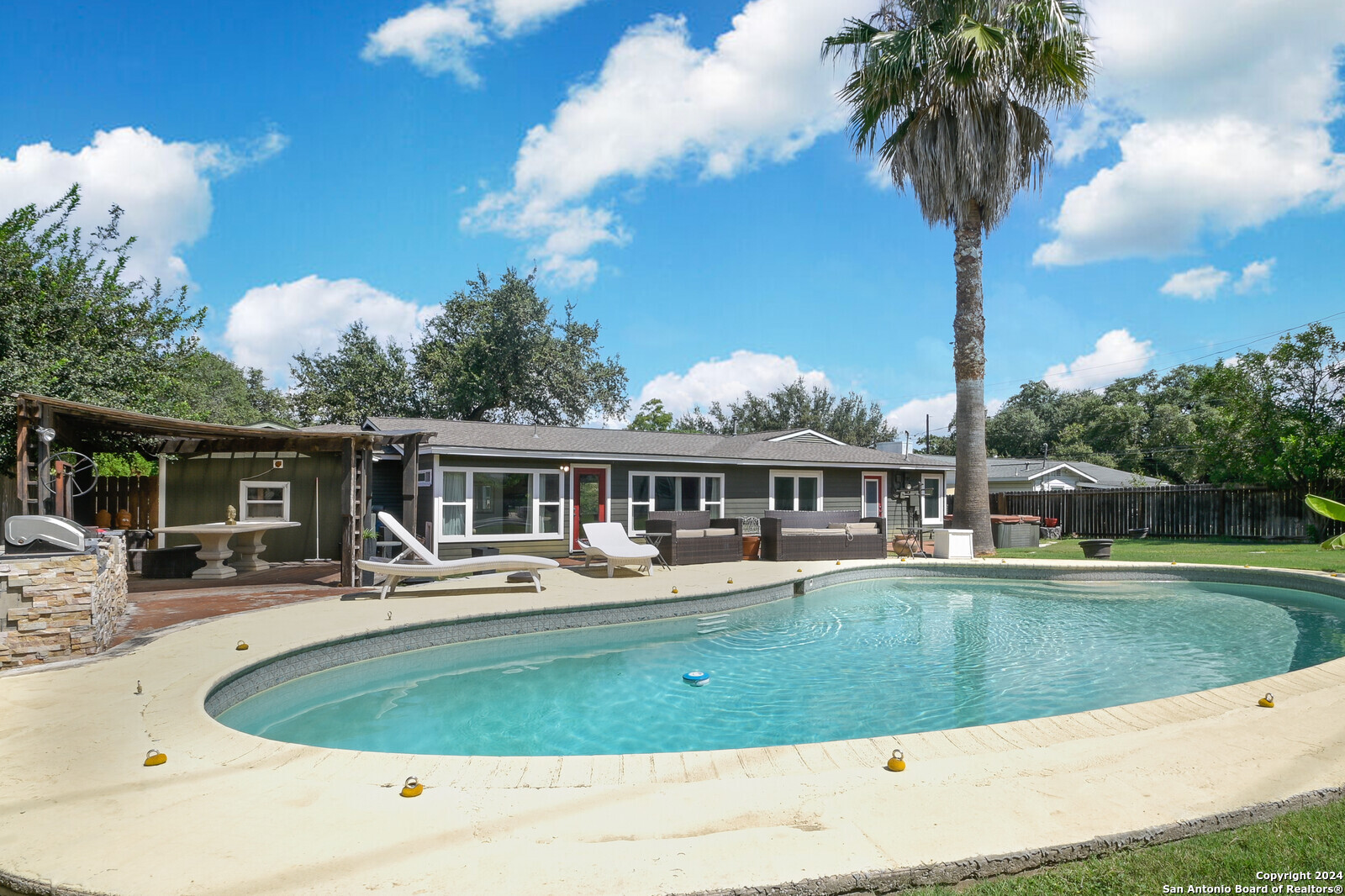 a house view with swimming pool and trees in the background