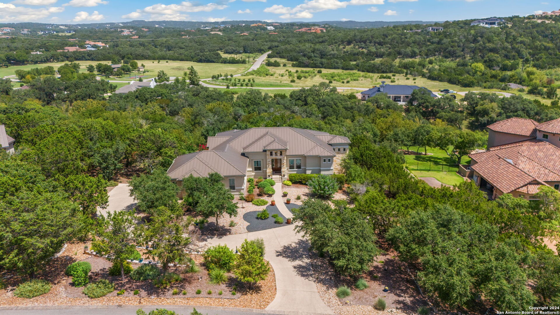 an aerial view of a houses with a yard and lake view