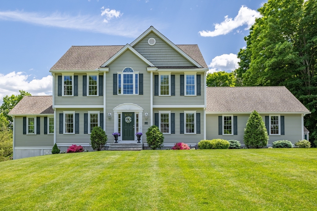 a front view of a house with a yard and trees