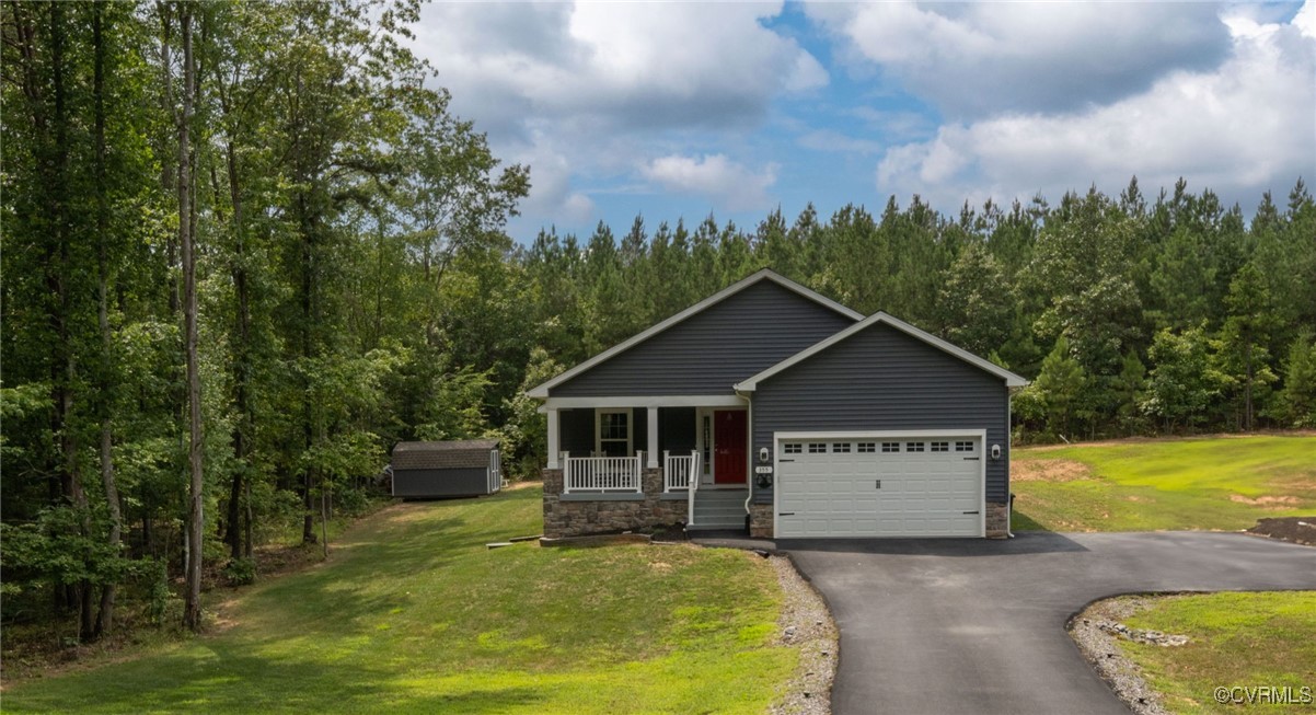 View of front of house with a porch, a garage, and