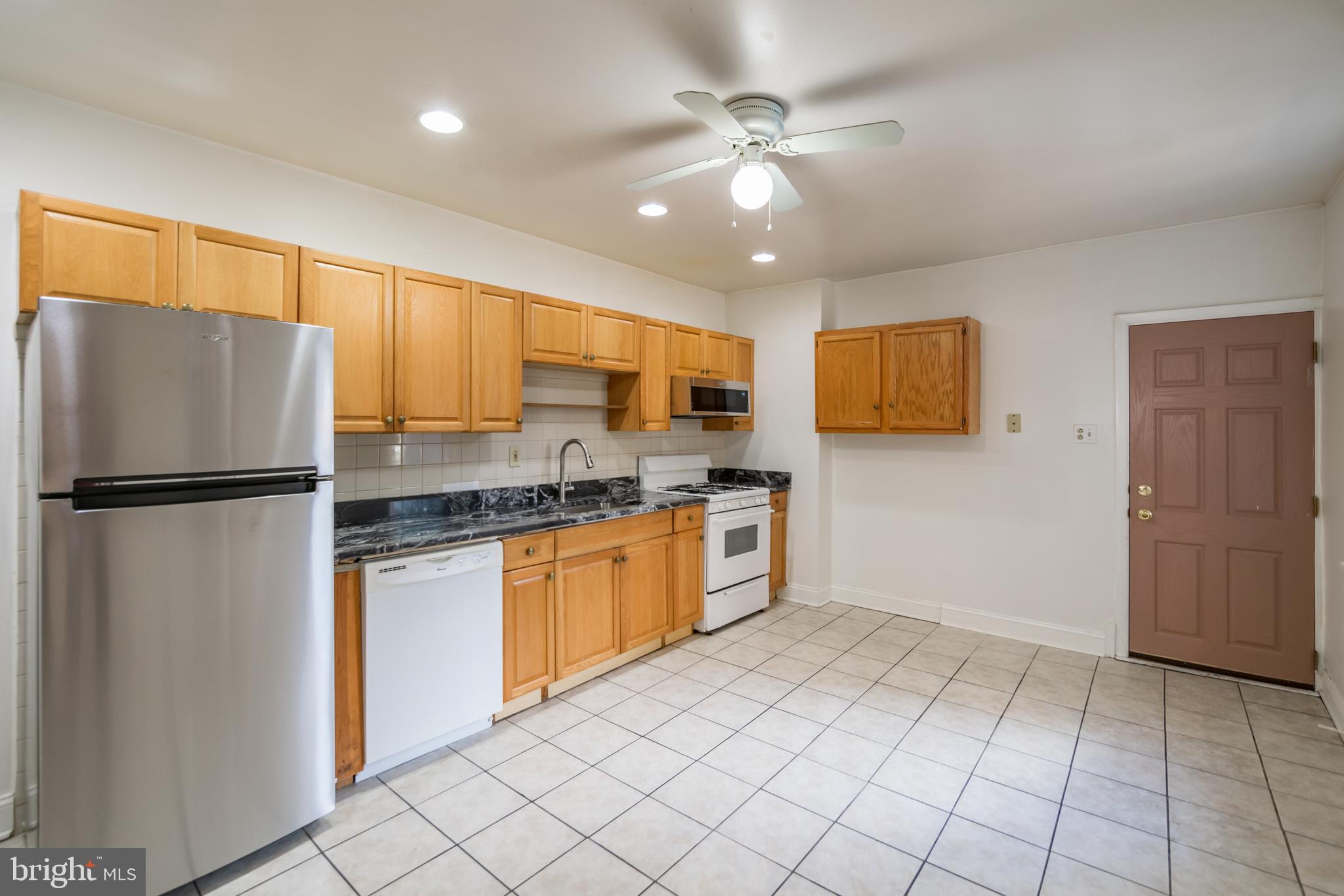 a kitchen with stainless steel appliances granite countertop a refrigerator a sink and a stove