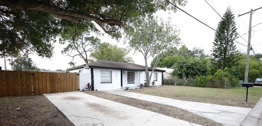 a front view of a house with a garden and trees