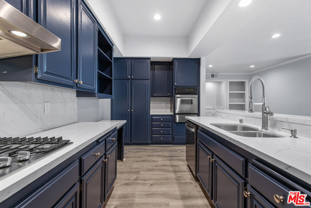 a kitchen with stainless steel appliances granite countertop a sink stove and refrigerator