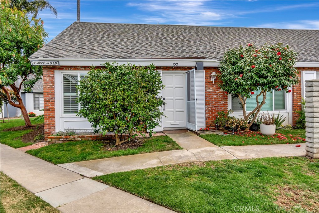 a front view of a house with a yard and potted plants