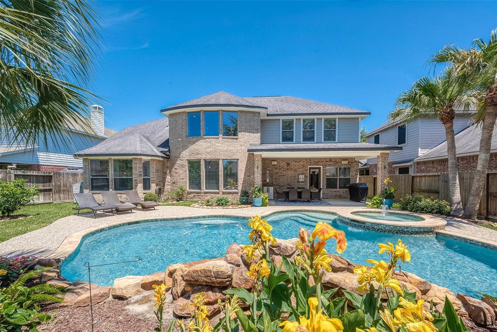 a front view of a house with swimming pool having outdoor seating