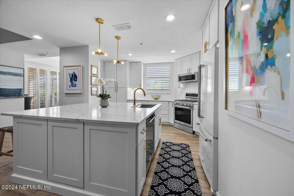 a kitchen with stainless steel appliances a sink and a refrigerator