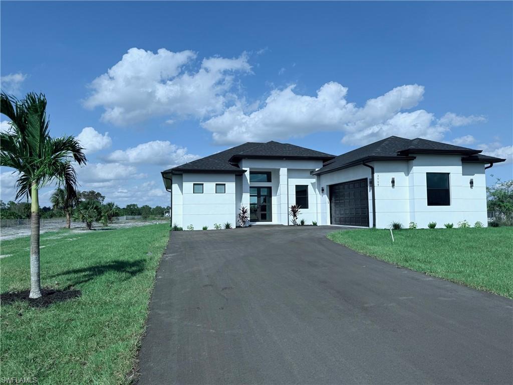 a front view of a house with a yard and garage