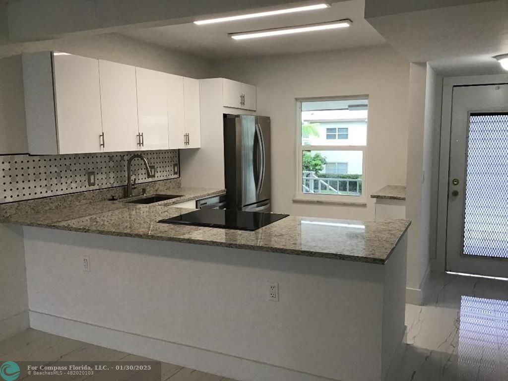 a kitchen with stainless steel appliances granite countertop a sink and a window