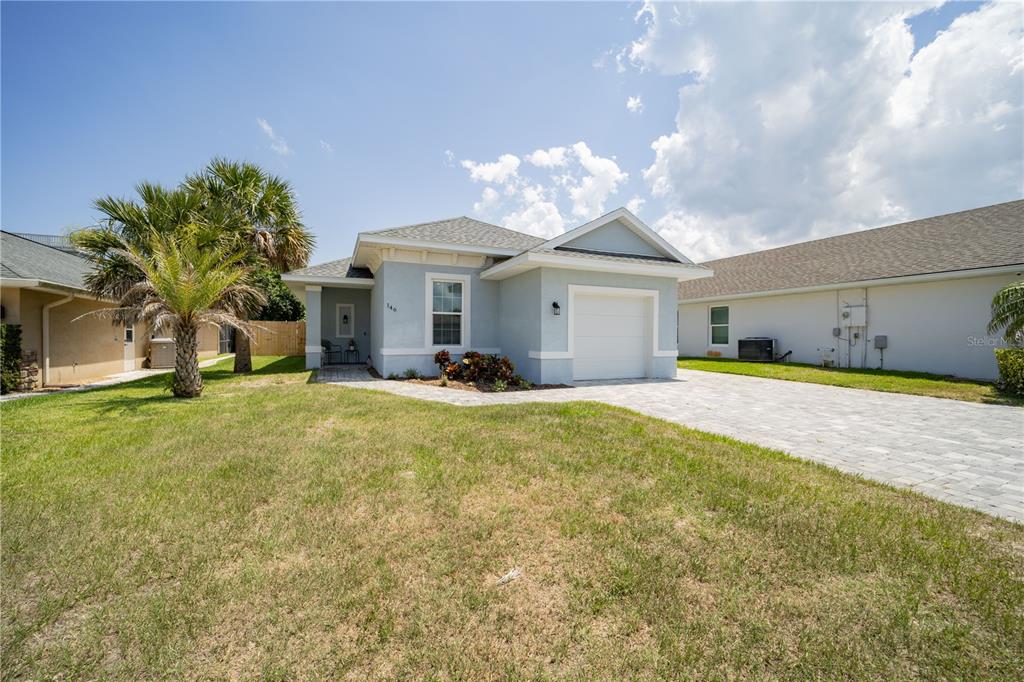 a view of a house with a yard and a garage