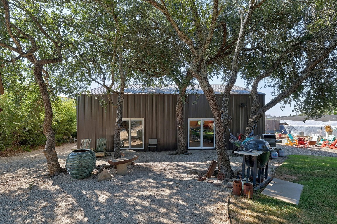 a view of a patio with table and chairs potted plants and large tree