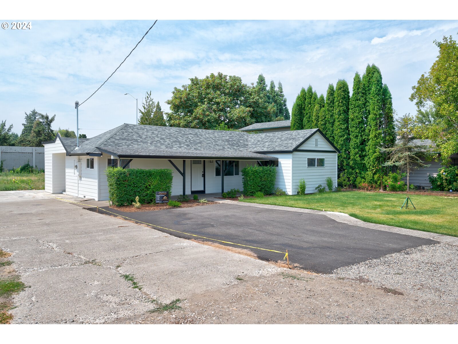 a front view of a house with a yard and trees