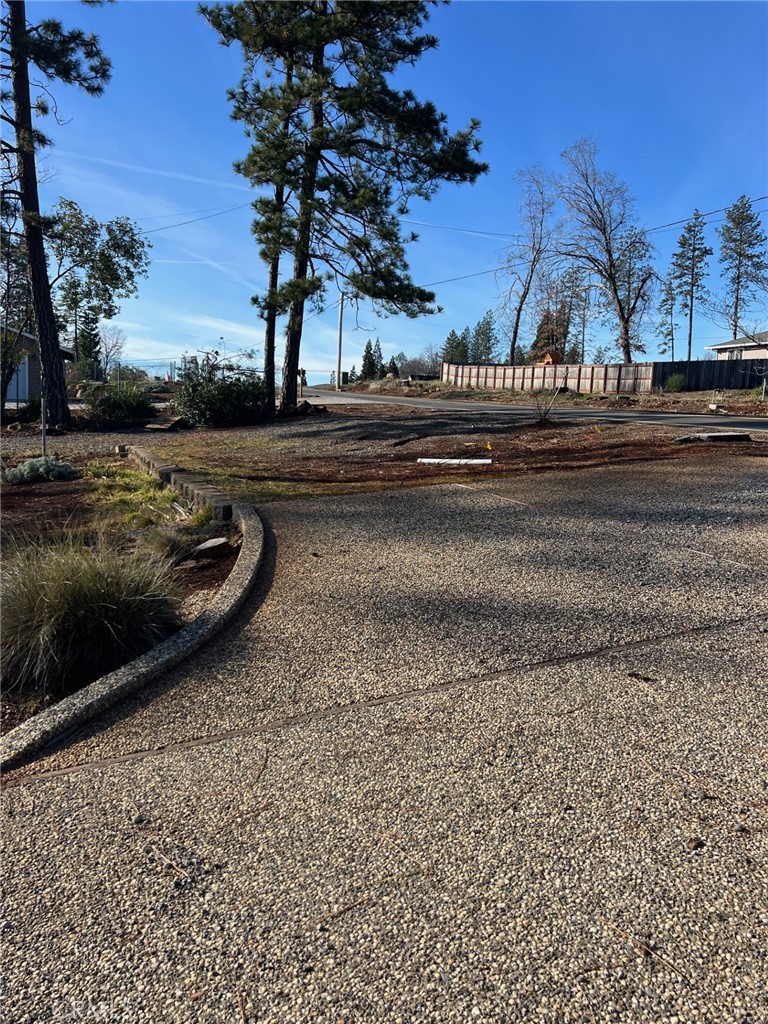 a view of a yard with cars parked on the roadside