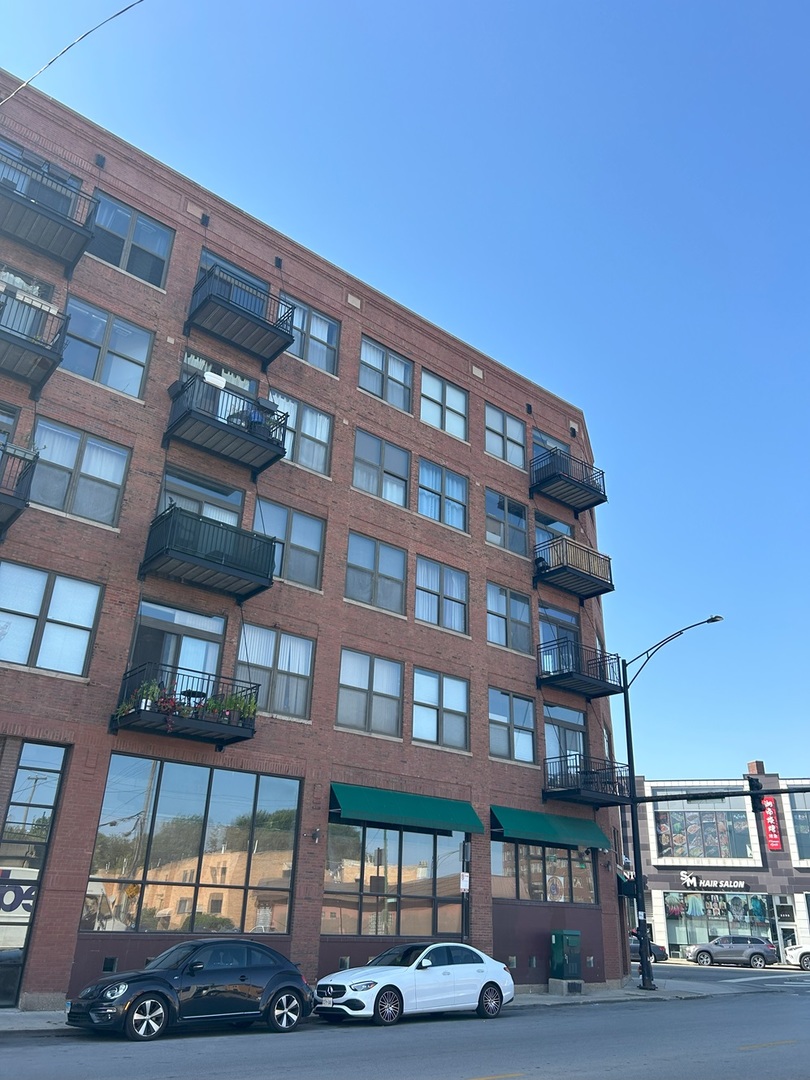 a front view of a building with lot of cars parked