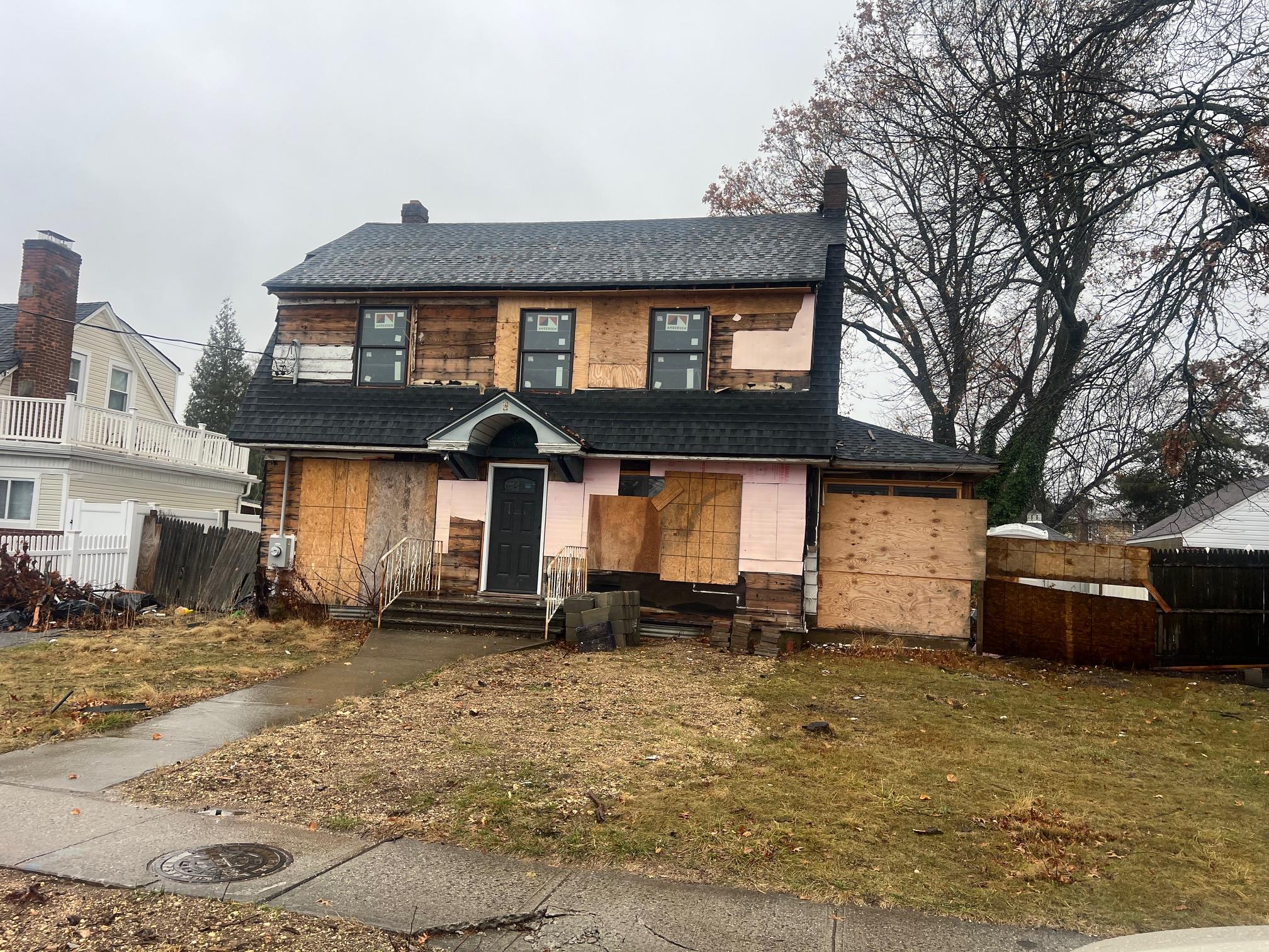 View of front of property featuring a garage and a front lawn