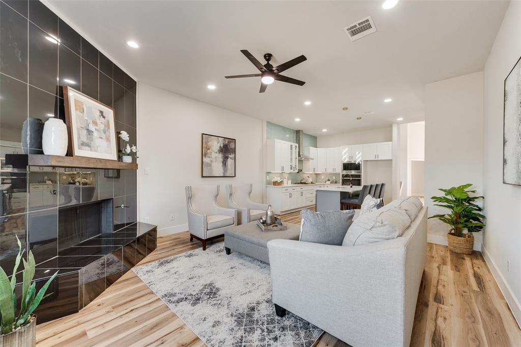 a living room with furniture a fireplace and a chandelier