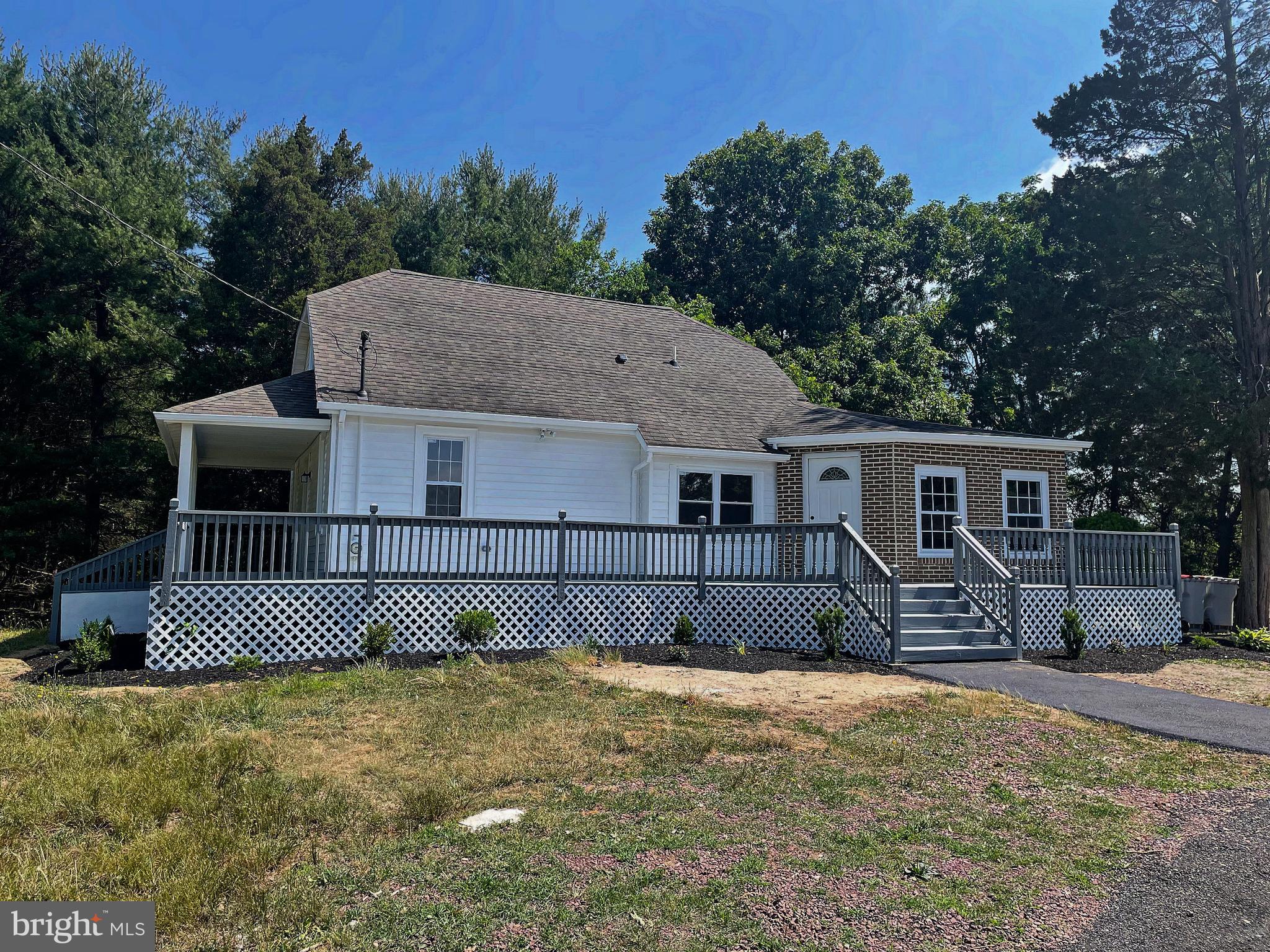 a front view of a house with a yard and trees