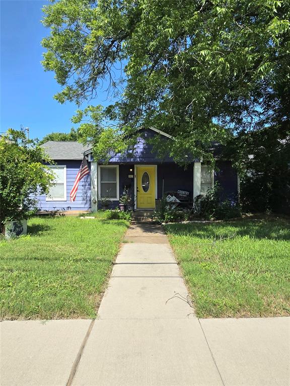 a front view of a house with a yard and potted plants