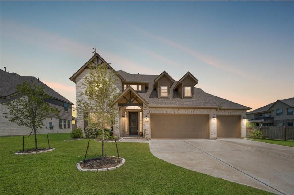 a front view of a house with a yard and tree