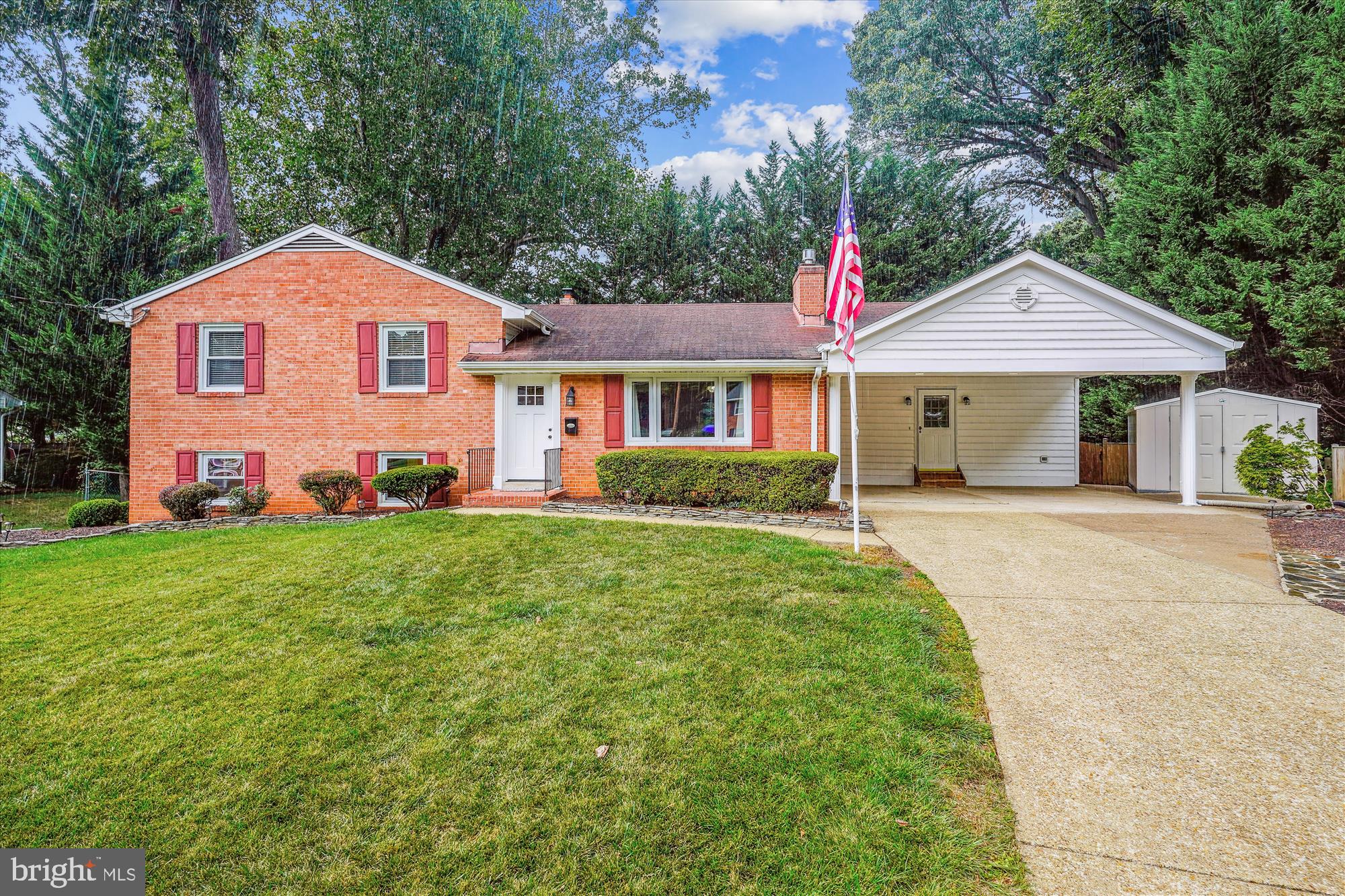 a front view of a house with a yard and trees