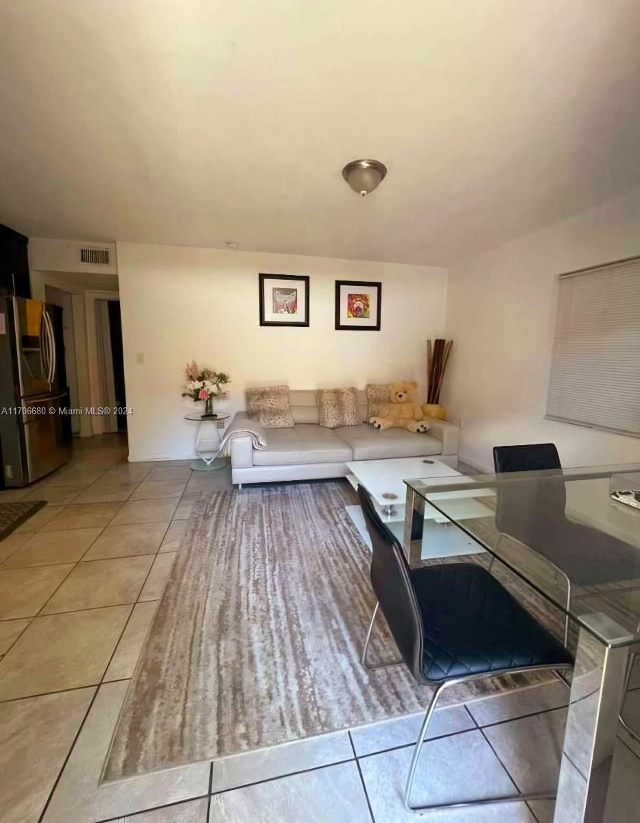 a living room with a couch and a view of kitchen