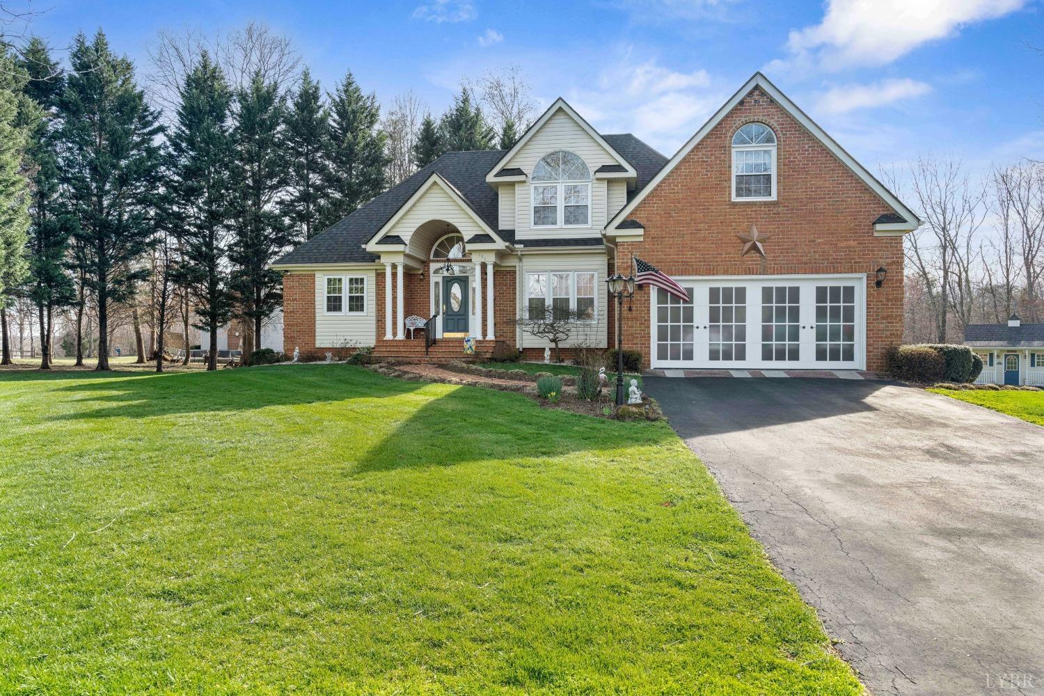 a front view of a house with a yard and trees