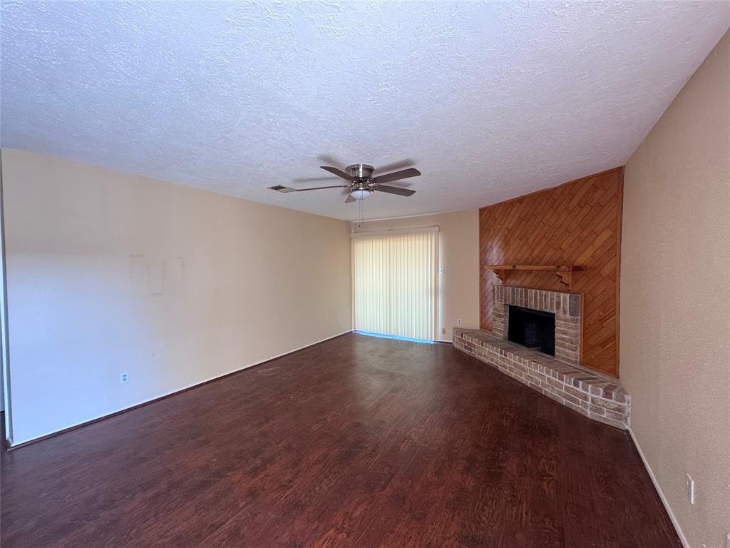 a view of an empty room with a fireplace and a window