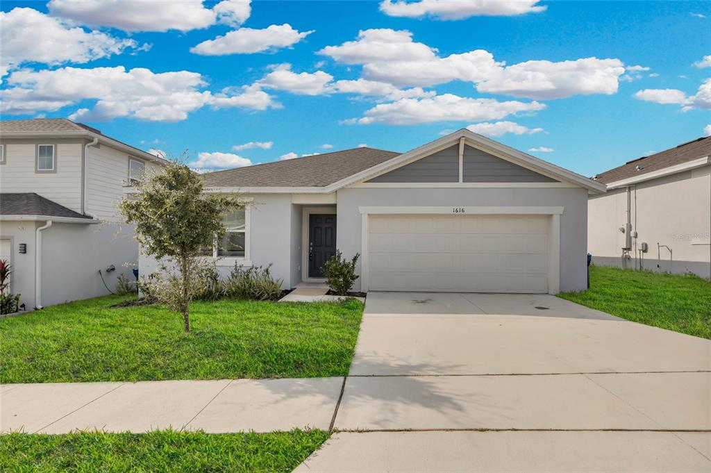 a front view of a house with a yard and garage