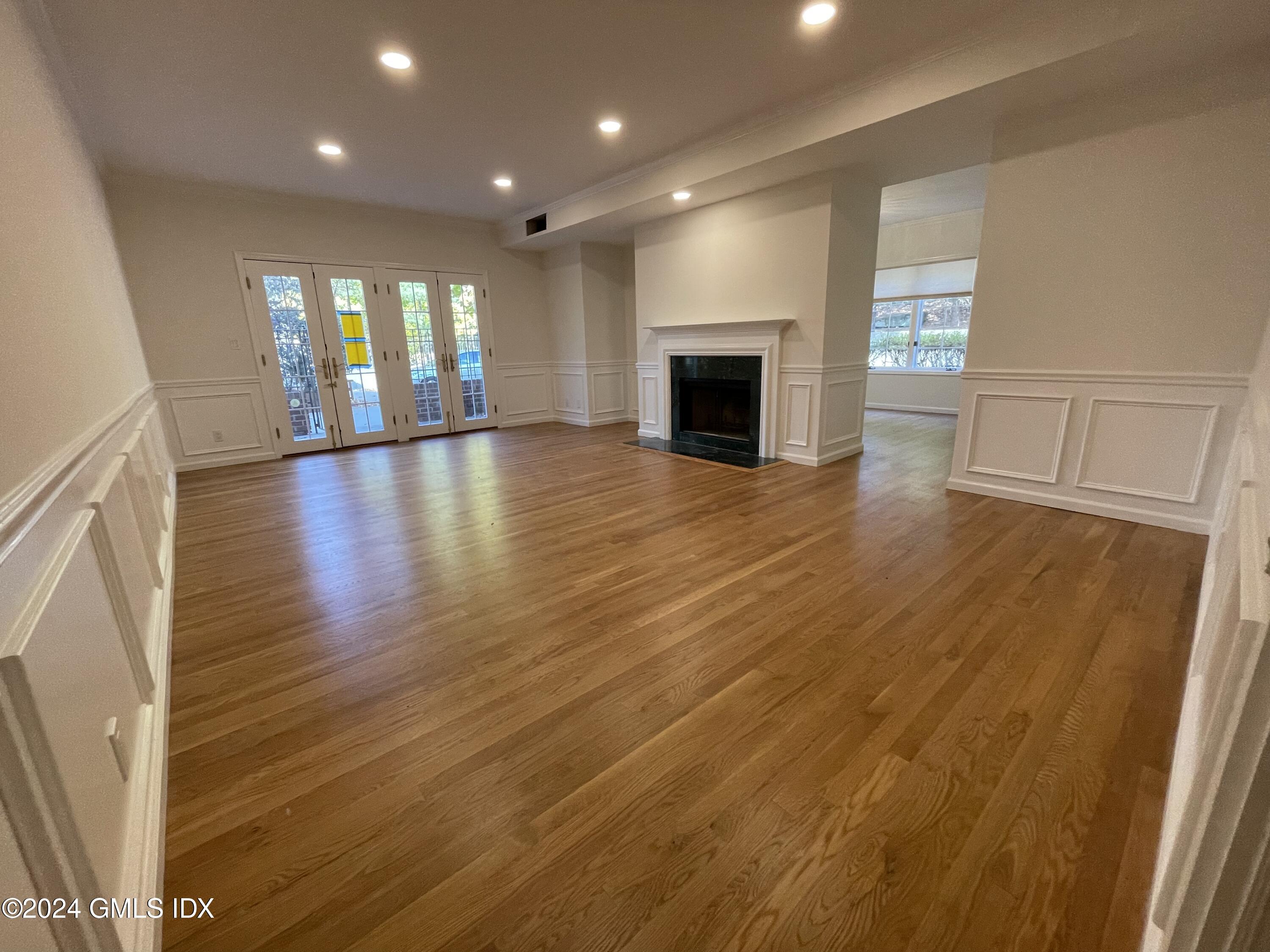 an empty room with wooden floor and fireplace