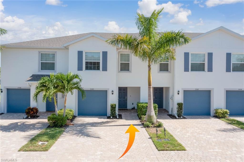 a view of a house with a yard and palm trees