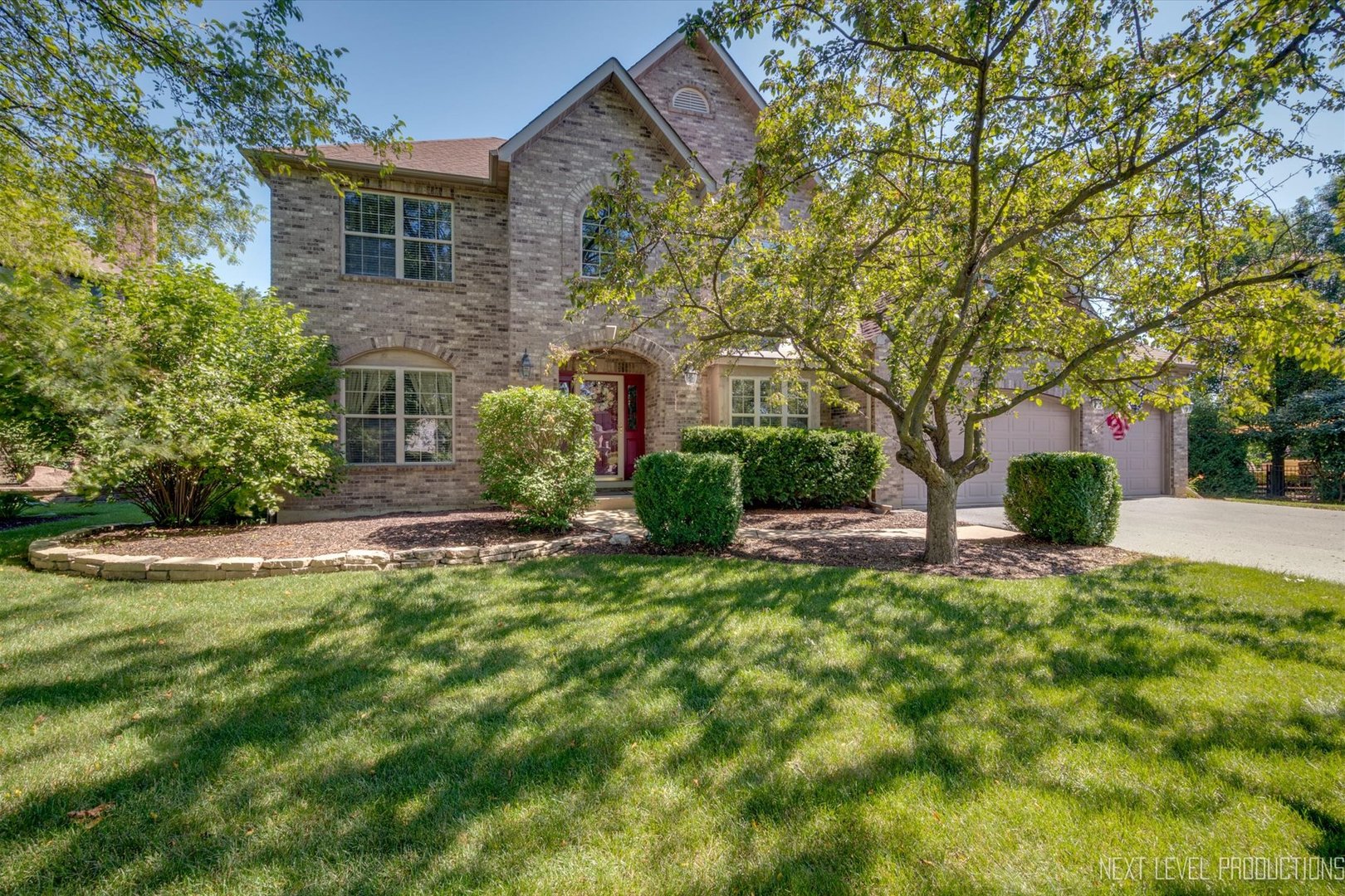 a front view of a house with a yard and trees