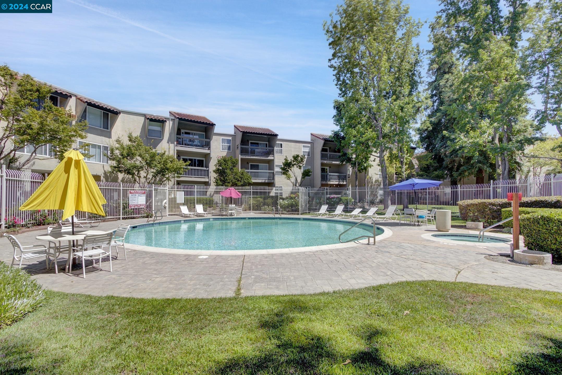 a view of backyard with swimming pool and seating