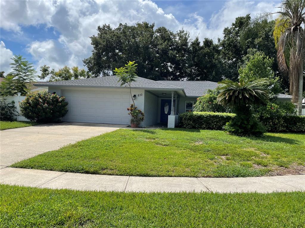 a front view of a house with a garden and yard