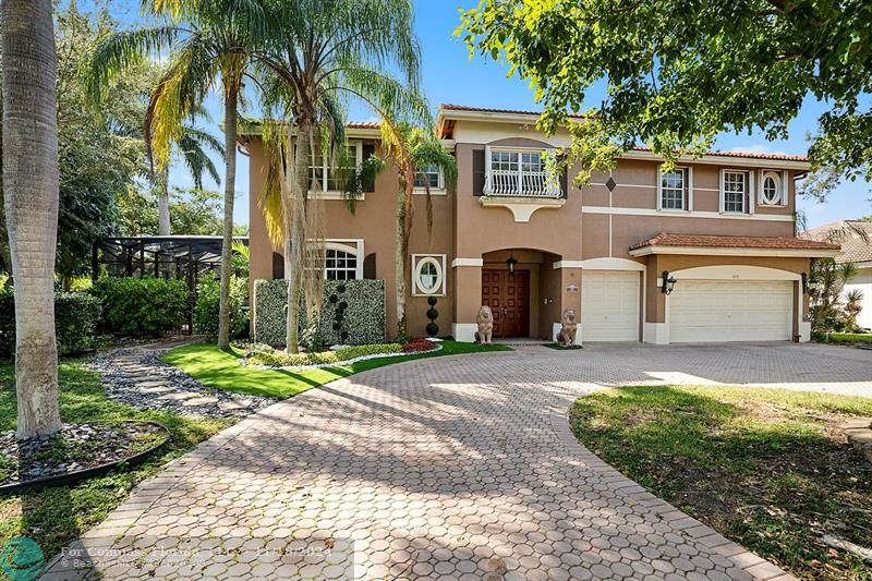 a view of a house with a yard and palm trees