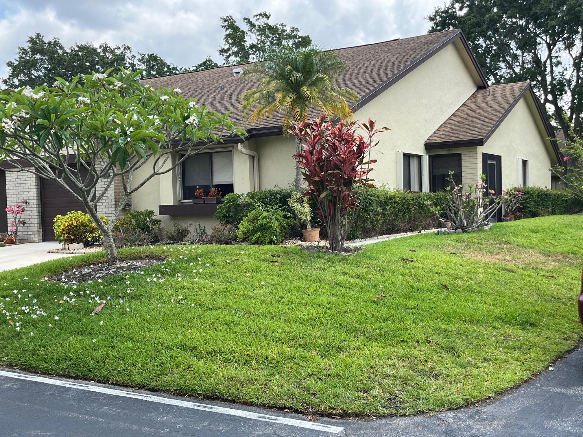 a front view of a house with a garden and plants