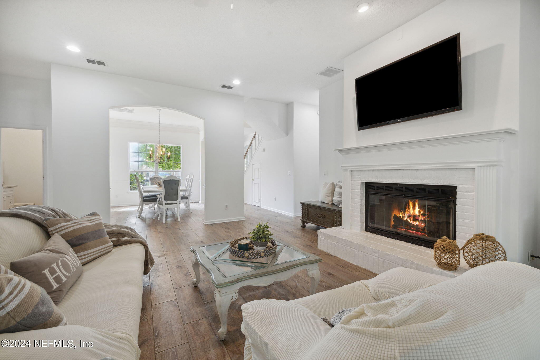 a living room with furniture a fireplace and a flat screen tv